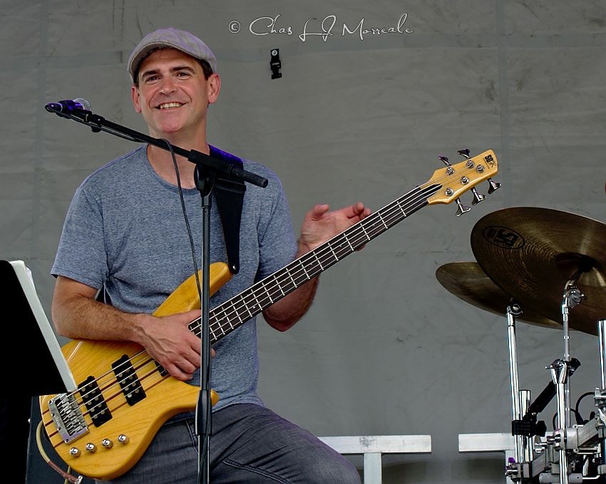 Matt Williams smiling with his bass guitar during a performance